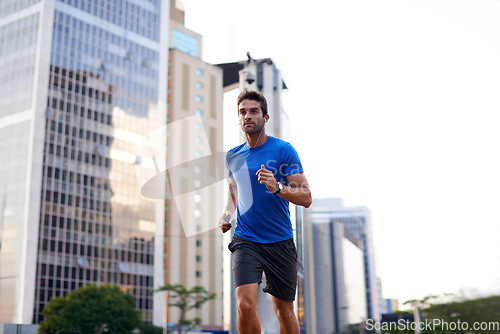 Image of Sports, exercise and man running in the city for health, wellness or training for a marathon. Fitness, runner and male athlete doing an outdoor cardio workout for endurance or speed in an urban town.