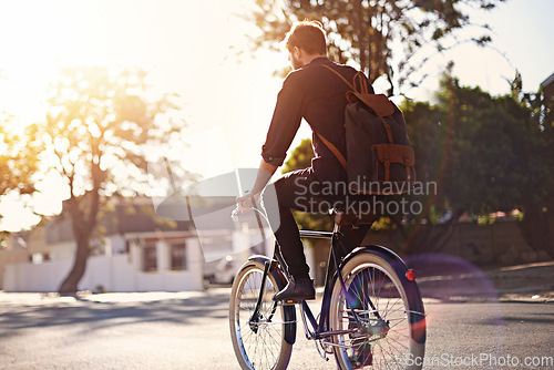 Image of Travel, bicycle and back of man in road with lens flare for exercise, commute and cycling in morning. Transport, city and male cyclist on bike for eco friendly traveling, carbon footprint and journey