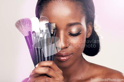 Image of Beauty, makeup and brushes, black woman in studio with cosmetic application tools and glamour. Skincare, brush and cosmetics, facial skin care glow, model with luxury contour tool on white background