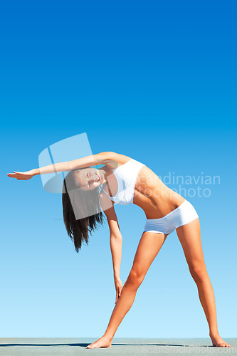 Image of Woman, yoga and stretching body for workout, exercise or fitness standing on floor against blue sky. Calm and peaceful female yogi in warm up arm stretch for healthy balance outdoors on mockup space