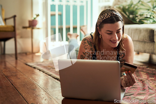 Image of Computer, credit card and woman with home online shopping, e commerce and fintech, loan or payment on floor. Happy person relax and typing her banking information on laptop for website ecommerce