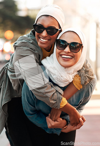 Image of Islamic woman, friends and piggyback in city with freedom, youth and comic adventure together in street. Muslim women, happy and walking in metro with funny game, sunglasses and support in Qatar