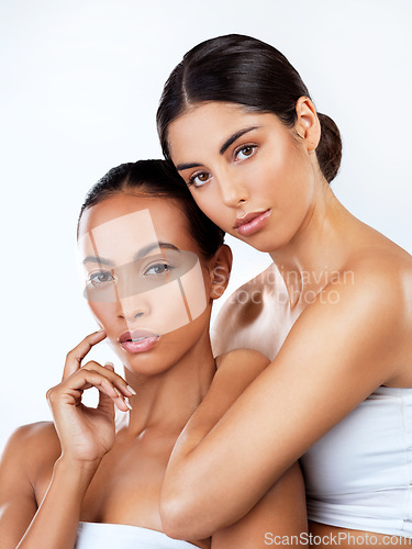 Image of Woman friends, studio portrait and cosmetics for self care, beauty or wellness by white background. Women, skincare and together for support, isolated or diversity with natural glow, face with makeup