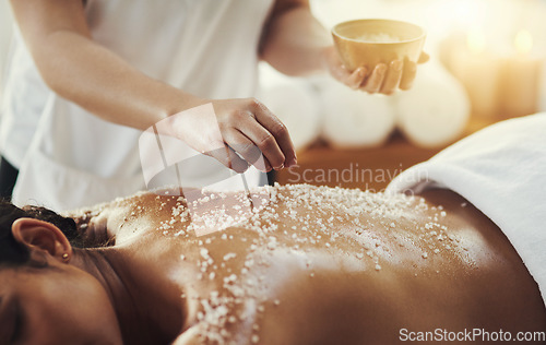 Image of Woman, hands and salt in massage at spa for skincare, exfoliation or body treatment at resort. Hand of masseuse applying salts to back skin for relaxation, therapy or zen in healthy wellness at salon