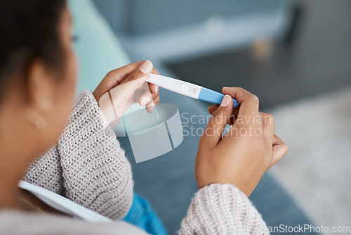 Image of Pregnancy test, woman hands and waiting at home for results on a living room couch. House, female person and hand with medical and fertility testing stick to show pregnant sign alone on lounge sofa