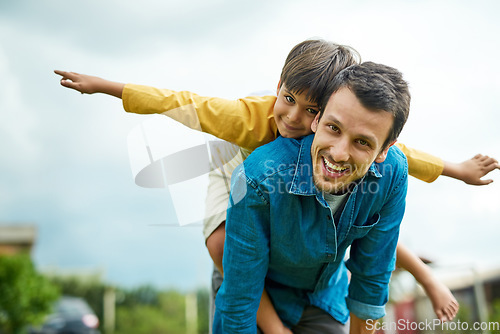 Image of Portrait, children and a son on back of his dad outdoor in the garden to fly like an airplane while bonding together. Family, kids and a father carrying his boy child while playing a game in the yard