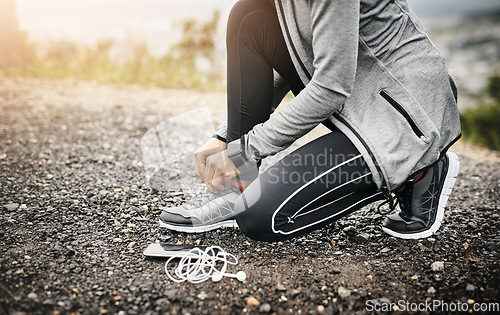 Image of Closeup, headphones and woman tie shoes, fitness and healthy with runner outdoor, wellness and training. Female person, athlete and girl with technology, hands and practice to start running and laces