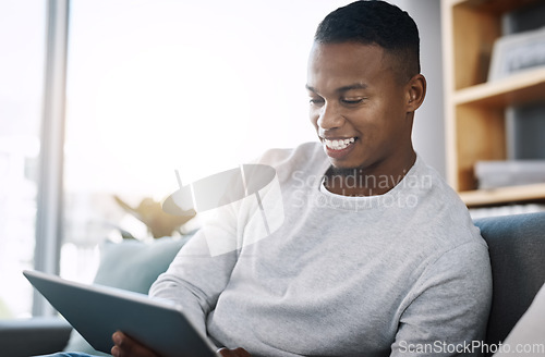 Image of Living room, tablet and happy man on couch browsing social media meme, email or streaming video subscription service. Happiness, internet and guy networking with smile on face reading website on sofa