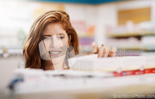 Image of Happy woman, shopping and pharmacy on shelf for drugs, pills or medication for healthcare at store. Female person, customer or patient checking pharmaceutical products, medicine or stock at a clinic