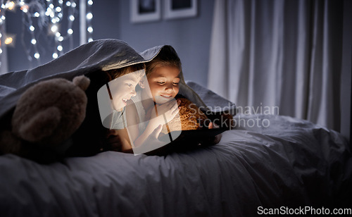 Image of Night, tablet and siblings in bed, home or watching a movie, film or cartoon with happiness. Children, kids or brother with sister, technology or online games with a smile, dark or relax in a bedroom