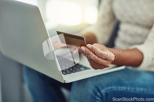 Image of Laptop, credit card and woman online shopping with payment on the internet on her home living room sofa. Ecommerce, computer and hands of person doing website payment on an app, connection or web