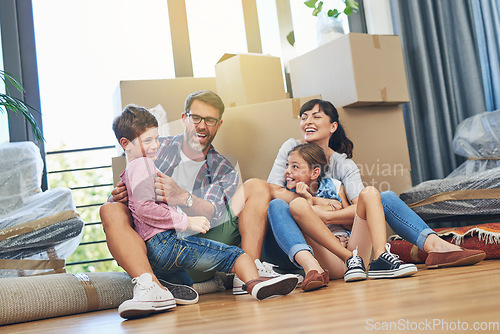 Image of Children, parents and laughing in apartment with box on living room floor with happiness for lifestyle. Family, boxes and excited in new house with investment in a mortgage for saving and wealth.