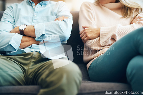 Image of Divorce, angry and couple fight arms crossed due to family law problem in a marriage with conflict in a home lounge. Anger, living room and partner or people frustrated, depressed and mad on a sofa