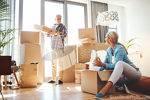 Image of Real estate, property and a senior couple moving house while packing boxes together in their home. Box, investment and retirement with old people unpacking in the living room of their new apartment