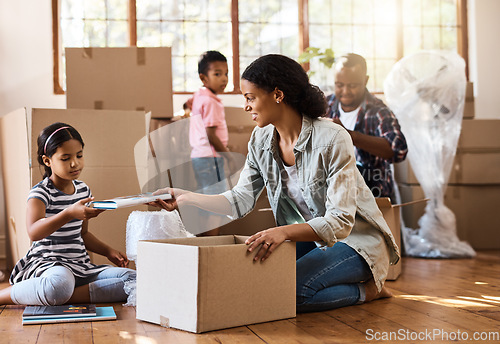 Image of Boxes, moving and family packing in home living room together with children, mom and dad. Property, real estate investment and house move with couple, kids helping box and cardboard unpacking