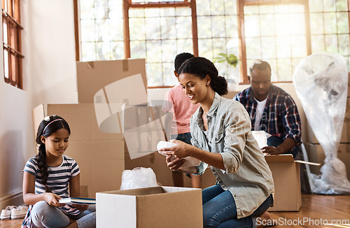 Image of Boxes, moving and family packing in home living room together with children, mom and dad. Property, real estate investment and house move with couple, kids helping box and cardboard unpacking