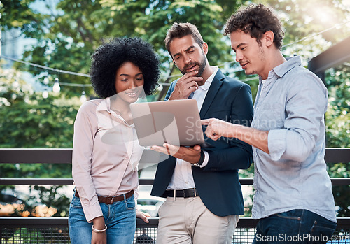 Image of Teamwork, laptop and business people together outdoor, working and brainstorming. Collaboration, computer and group of employees, men and black woman planning, meeting and cooperation in urban city.