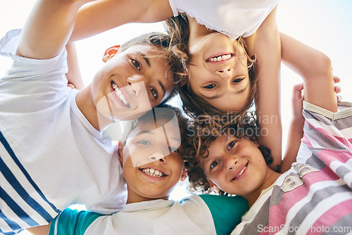 Image of Portrait, low angle and a group of happy siblings or huddled together or hug in solidarity and smiling outdoors. Circle, brothers and sisters or excited children play or bonding and face outside