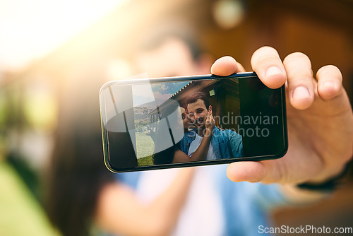 Image of Happy couple, kiss and phone camera for selfie, photo or profile picture together in relationship outdoors. Hand of man holding smartphone with woman kissing cheek for love, memory or capture outside