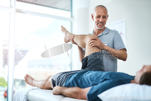 Image of Healthcare, physiotherapist and patient with leg injury, stretching and recovery with treatment, healing or care. Male person, employee or chiropractor with a client, physical therapy or consultation