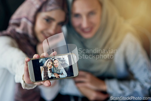 Image of Muslim women, friends and selfie with cellphone, smile and happiness for post on blog, web or social media. Happy islamic woman, group and smartphone for photography, profile picture or memory on app