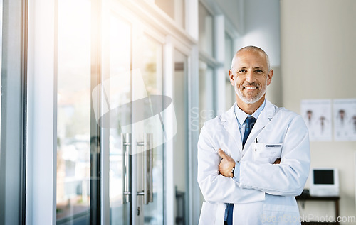 Image of Mature doctor, smile and portrait with arms crossed in hospital feeling proud from medical work. Healthcare, wellness and professional employee with happiness from health support and physician job