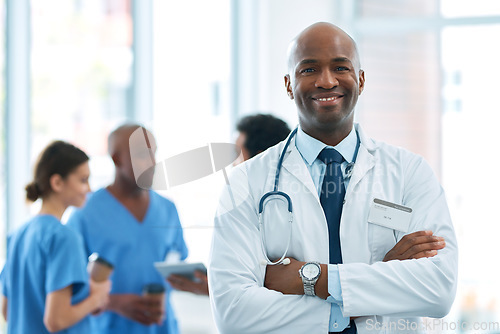 Image of Man, leader and portrait of doctor in hospital, healthcare or clinic with medical expert nurses to trust in quality care. Black person, medicine and happy neurosurgeon, arms crossed or confidence