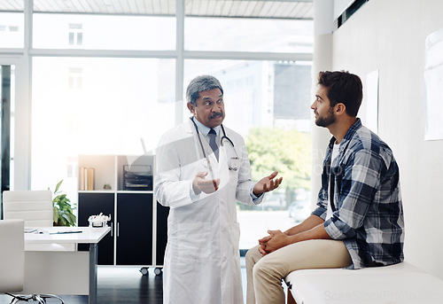 Image of Healthcare, doctor and patient in consultation with expert advice, information and support in discussion. Medicine, health care and Indian man in doctors office consulting with medical professional.