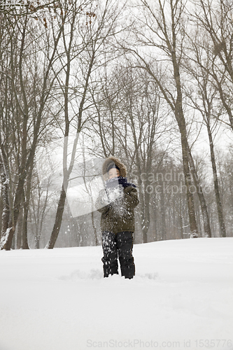 Image of boy plays with snow