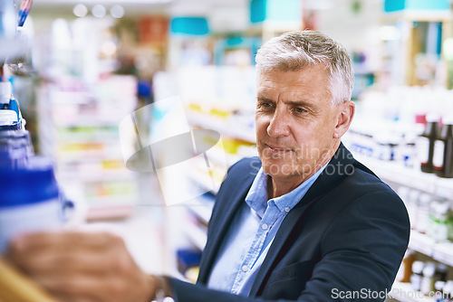 Image of Senior man, pharmacy or customer searching for retail healthcare pills, medicine in drugstore. Looking, businessman or mature customer checking or choosing medication or medical vitamins on shelf