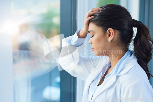 Image of Stress, doctor and woman by window in hospital with worry, anxiety and tired with headache in clinic. Healthcare, mental health and sad female health worker with stressed out, depression and burnout