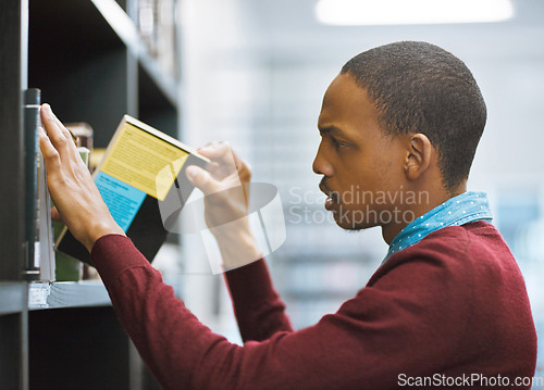 Image of Education, university and student in the library picking a book or on shelf for exam preparation and in college. Research, learning and scholar browsing journal or academic and educational course