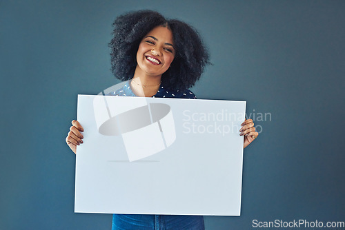 Image of Happy, mockup and portrait of a woman with a sign isolated on a blue background in studio. Smile, showing and young corporate copywriter with a blank board for branding, design and information space