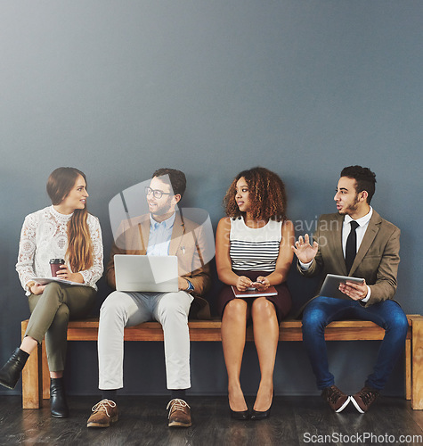 Image of Business people, we are hiring talk and conversation before a job interview waiting and sitting in line. Communication, technology and staff in discussion for recruit meeting with mockup wall