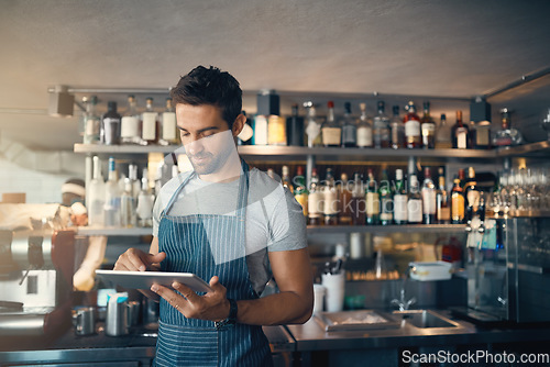 Image of Man in restaurant, tablet and inventory check, small business and entrepreneur in hospitality industry. Male owner, scroll and cafe franchise, digital admin and stock taking with connectivity