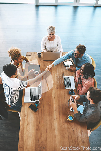 Image of Handshake, above and business people in a meeting at work for onboarding and welcome. Happy, interview and corporate employees shaking hands for thank you, deal or partnership in a group discussion