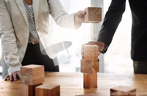 Image of Hands, wood building blocks and business people in partnership with strategy, problem solving and support. Teamwork, wooden toys and together with puzzle, synergy and mindset for solution in office