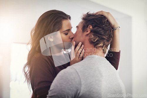 Image of Couple, love and kissing in home for romantic bond, quality time and care together. Young man, woman and kiss for romance of lovers in happy relationship, intimate moment and passionate affection