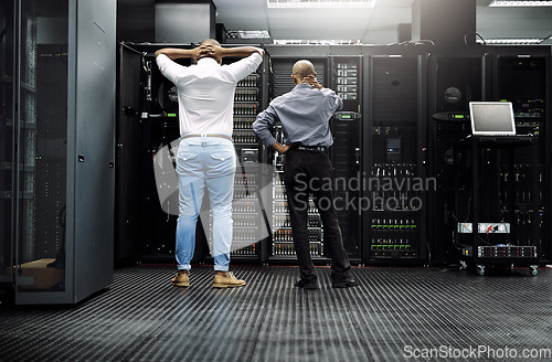 Image of Server room, it support or electrician fixing a problem for hardware maintenance or stressful glitch crisis. Confused or back of worried technicians or electrical engineers in information technology