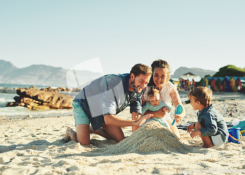 Image of Sandcastle, parents and children at the beach with bonding, love and support. Baby, mom and dad together with kids playing in the sun with happiness and smile by the ocean and sea with family