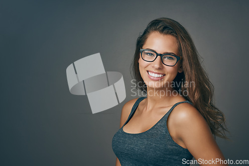 Image of Smart woman, glasses and portrait with happiness and mockup from eyewear. Gray background, studio and modern style with female person and model with beauty and casual fashion with smile and eye care