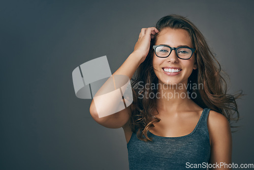 Image of Young woman, glasses and portrait with happiness and mockup from eyewear. Gray background, studio and mockup with female person and model with beauty and casual style with a smile and eye care