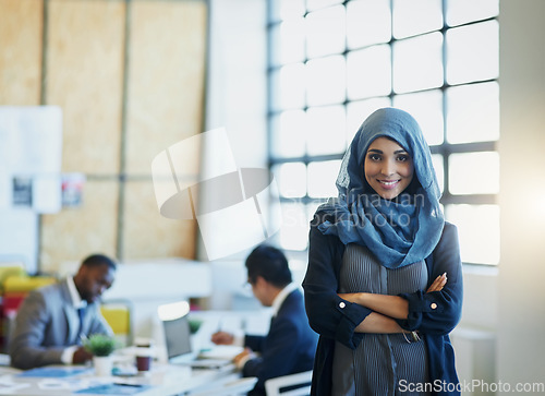 Image of Muslim woman, business and portrait in an office with a smile and arms crossed for career pride. Arab female entrepreneur or leader at a diversity and corporate workplace with a positive mindset