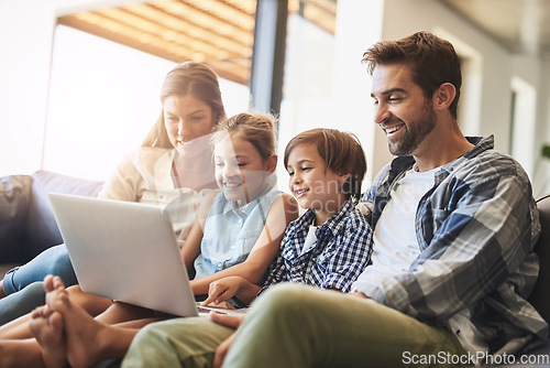 Image of Family, laptop and kids smile with parents on a living room sofa with education game online. Mom, dad and young children together with bonding, care and love in a house streaming a video on computer