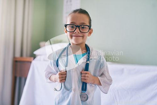 Image of Girl child, portrait and playing doctor with smile, glasses and holding stethoscope in home, hospital or clinic. Female kid, play medic and happy with excited face, learning and game for development