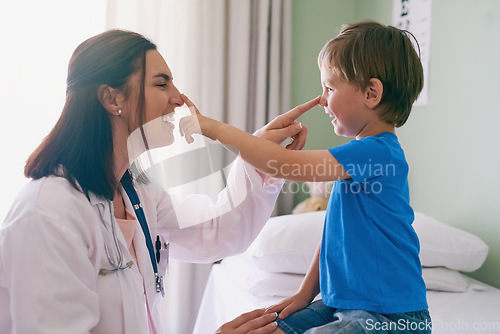 Image of Woman doctor, playing and child at a hospital for healthcare and medical consultation. Fun, nose poke and pediatrician working with a laugh and happiness in a clinic with boy patient with exam