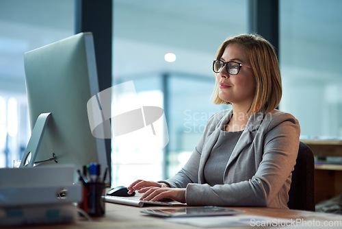 Image of Computer, typing and business woman in office working late on project at night alone. Desktop, professional and female person writing email, report or planning, reading and overtime for deadline.