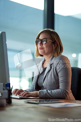 Image of Computer, typing and business woman in office working late on project at night alone. Desktop, professional and female accountant writing email, report or planning, reading and overtime for deadline.