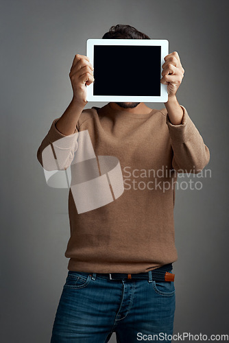 Image of Tablet screen, mockup and man covering face in studio isolated on a gray background. Touchscreen, hiding and male person with space for marketing, advertising and technology for commercial promotion.