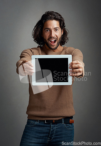 Image of Portrait, tablet screen and excited man with mockup in studio isolated on a gray background. Touchscreen, face and male person with marketing, advertising and technology for surprise promotion.